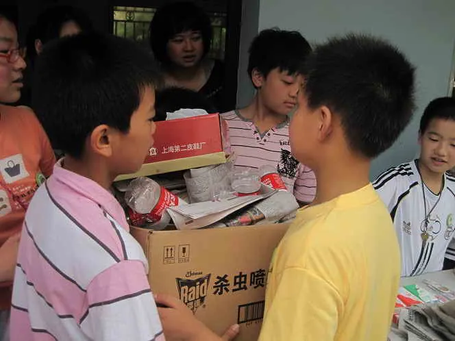 同学们拿着收到的废品塑料瓶搬入临时仓库！